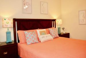 a bedroom with a bed with orange sheets and pillows at Holiday Isle 107 in Dauphin Island