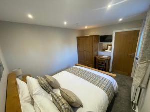 1 dormitorio con 1 cama con almohadas en Crich Lane Farm en Alfreton