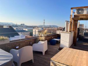 uma varanda com uma mesa e cadeiras num telhado em Rose cosy, tiny studio with shared rooftop terrace and jacuzzi em Budapeste