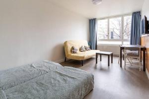 a bedroom with a bed and a chair and a table at La villette ; super Studio privé Joli Spacieux; La Multiculture in Aubervilliers