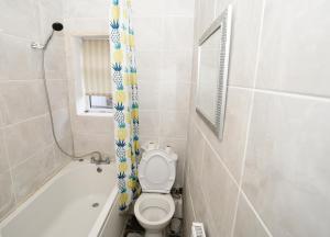 a small bathroom with a toilet and a bath tub at AG HOUSE in Manchester