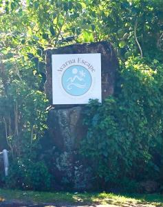 a sign on a rock in the middle of a bush at Avarua Escape, Rarotonga in Avarua