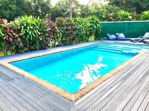 a small swimming pool with a wooden deck at Avarua Escape, Rarotonga in Avarua