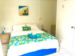 Un dormitorio con una cama con una bolsa azul. en Avarua Escape, Rarotonga en Avarua