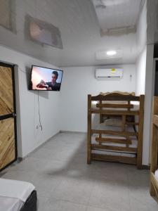 a room with two bunk beds and a tv on the wall at Apartamentos Vistas del Caribe Sede Campestre in Cartagena de Indias