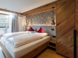 a bedroom with a large white bed with red pillows at Ferienhof Oblasser in Mayrhofen