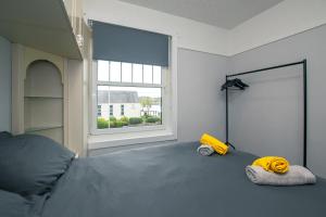 Cosy & Central 2BD Apartment Milngavie, Glasgow في ميلنغافي: غرفة نوم بسرير ونافذة كبيرة