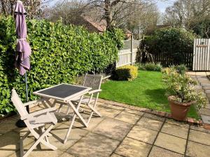 a patio with a table and two chairs and an umbrella at Cloverleaf in Saltfleetby Saint Clement