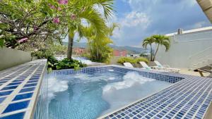 uma grande piscina com azulejos azuis num pátio em Hotel MS Chipichape Plus em Cali