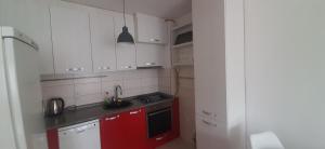 - une petite cuisine avec des placards rouges et blancs dans l'établissement Apartman Stella Istočno Sarajevo, à Lukavica