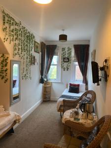 a bedroom with a bed and a couch and a table at The Palms Guest house in Torquay