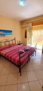 una camera da letto con un grande letto con una coperta rossa di 3 bedrooms apartement at Alcamo 100 m away from the beach with sea view enclosed garden and wifi ad Alcamo