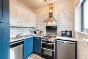 a kitchen with blue cabinets and a stove top oven at Greenville B&B in Kenmare