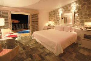 a bedroom with a large white bed and a table at Las Brisas Acapulco in Acapulco