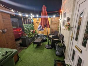 a room with a patio with chairs and an umbrella at Flemingate Cottage, Beverley in Beverley