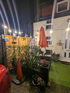 a patio with a red umbrella and a building at Flemingate Cottage, Beverley in Beverley