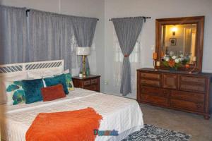 a bedroom with a bed with a mirror and a dresser at Adama Suites in Potters Village