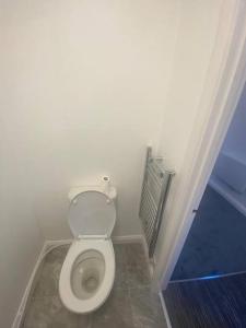 uma casa de banho com um WC branco num quarto em Guest House in Milton Keynes em Milton Keynes