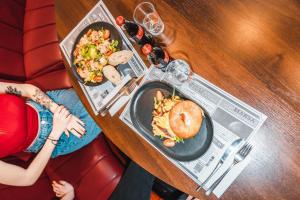 a woman sitting at a table with a plate of food at SeaSide Sopot - butikowe noclegi przy plaży in Sopot