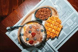 a table with a pan of food and waffles and berries at SeaSide Sopot - butikowe noclegi przy plaży in Sopot
