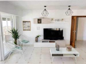 sala de estar con TV de pantalla plana y sofá en COSY FLATS 1ª LINEA VISTAS ESPECTACULARES, en Alicante