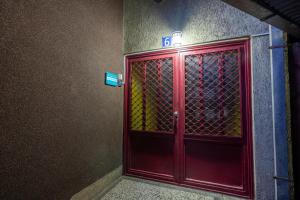 czerwone drzwi w pokoju z napisem w obiekcie Hostel Prishtina Backpackers w Prisztinie