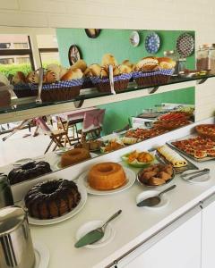 ein Buffet mit vielen verschiedenen Arten von Kuchen und Gebäck in der Unterkunft Hotel pousada a Cabana in Maceió