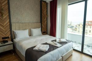 een slaapkamer met een bed en een groot raam bij Linda Port Hotel in Istanbul
