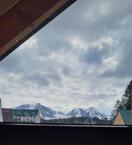 a view of a snowy mountain range from a window at Monte Pino Lux Apartments in Žabljak
