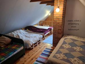 a room with two beds and a brick wall at Domek letniskowy w Szkotowie in Szkotowo