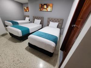 two beds in a small room with at Hotel Med Suites 94 in Barranquilla
