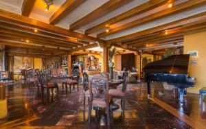 a room with a piano and chairs and a table at Hacienda Rumiloma in Quito +115 photos