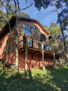 una casa con una terraza a un lado en Refúgio na Mata - Casa de campo, en Santo Antônio do Pinhal