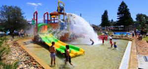 a group of people playing in a water park at NRMA Tathta Beachfront Holiday Park in Tathra