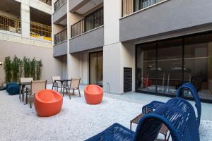 eine Terrasse mit Stühlen und Tischen vor einem Gebäude in der Unterkunft Apartamentos completos com academia ao lado da Av Paulista - Next Paulista in São Paulo