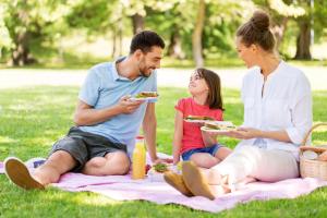 a family eating sandwiches while sitting on a picnic blanket at Lovely 4 Berth Holiday Home At Felixstowe Beach Holiday Park Ref 55008yc in Walton