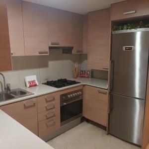 una cucina con frigorifero in acciaio inossidabile e lavandino di Bcn apartments a Hospitalet de Llobregat