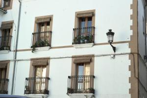 un edificio blanco con balcones y luz de la calle en Destino Deluxe Plaza De Santiago - 2 hab en Cáceres