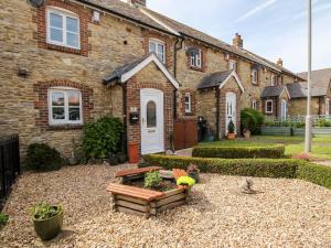 einen Garten vor einem Backsteinhaus in der Unterkunft Knapp Cottage in Weymouth