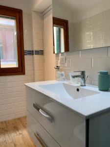 a white bathroom with a sink and a mirror at Casa Giardini in Venice