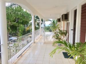 an empty porch of a house with a balcony at African Symbol Guest House in Montego Bay