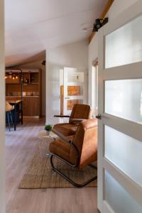 a living room with a leather chair and a table at Logies-Spier in Spier +40 photos