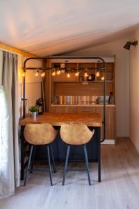 uma sala de jantar com uma mesa de madeira e 2 cadeiras em Logies-Spier em Spier