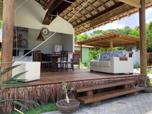 a wooden deck with a couch on a patio at Bons Ventos Camping e Glamping in Barra Grande