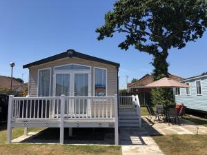 グレート・ヤーマスにあるBeautiful Caravan For To Hire At Hopton Haven Park In Norfolk Ref 80027tの庭のベンチ付きガゼボ