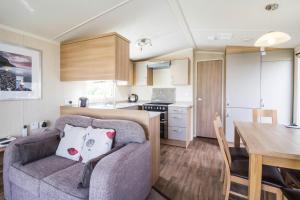 a living room and kitchen with a couch and a table at Beautiful Caravan For To Hire At Hopton Haven Park In Norfolk Ref 80027t in Great Yarmouth