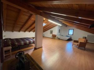 uma ampla sala de estar com um sofá e piso em madeira em Cimi&Clara em Saint Marcel