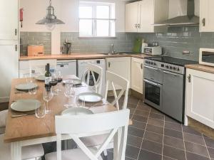 a kitchen with a wooden table with wine glasses on it at Lords Cottage in Coleford