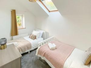 a bedroom with two beds and a window at Lords Cottage in Coleford