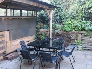 einen schwarzen Tisch und Stühle auf einer Terrasse in der Unterkunft Lords Cottage in Coleford